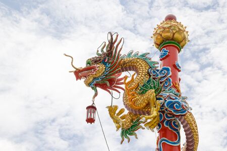 Dragon sculpture with blue sky, Dragon in Chinese temple Beautiful Dragon, Dragon wrapped around a poleの写真素材