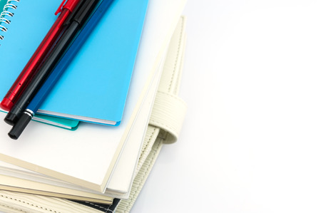 stack of organizer, notebooks, pen and pencil on white background