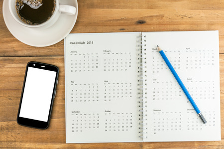 organizer with pencil, coffe cup and blank screen smart phone on wooden table, business concept
