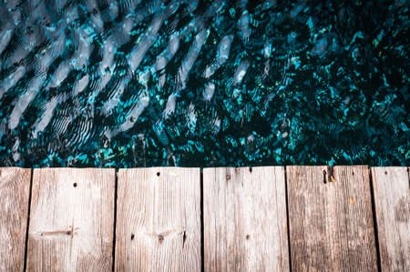 Wood planks against blue water backgroundの写真素材