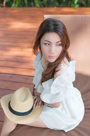 Young asian women with hat sitting at day bedの写真素材