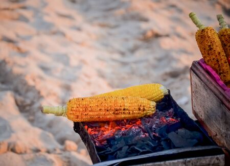 Corn grill on the stove with fire and charcoalの写真素材