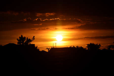 Beautiful sunset light in the evening over house silhouette.