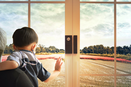 Rear view of young father carry son are look at the beautiful nature outside view of window. Happy...