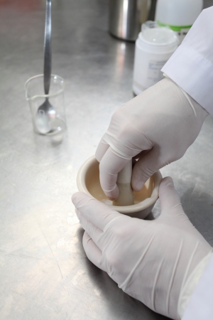 Pharmacist grinding material with mortarの写真素材