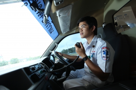 UBON RATCHATHANI, THAILAND â AUG 7, 2013 : Pornchai Kaotong on duty as a driver of ambulance contacts team with radio communication on Aug 7, 2013 in Ubon Ratchathani University hospital, Warinchamrab, Ubon Ratchathani, Thailand.のeditorial素材
