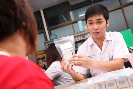 UBON RATCHATHANI, THAILAND â AUG 21, 2013 : Phanumas Yaosri a pharmacist counseling and informing his patient in pharmacy department on Aug 21, 2013 in Sappasitparsong hospital Ubon Ratchathani, Thailand.のeditorial素材