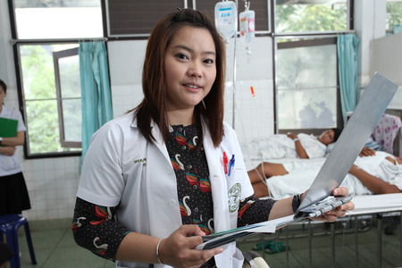 UBON RATCHATHANI, THAILAND â AUG 21, 2013 : Unidentified pharmacist holding patient profile chart on ward on Aug 21, 2013 in Sappasitparsong hospital Ubon Ratchathani, Thailand.のeditorial素材
