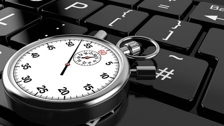 Stopwatch lying on computer keyboardの写真素材