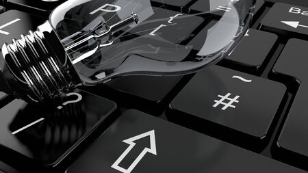 Light bulb lying on computer keyboardの写真素材