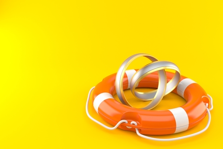 Wedding rings with life buoy isolated on orange backgroundの写真素材