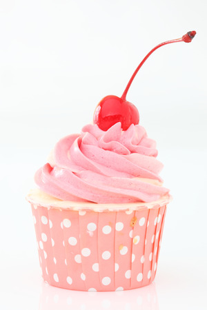 Cupcake with whipped cream and cherry isolated on whiteの写真素材