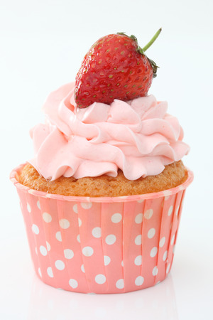 Delicious vanilla cupcake with strawberry frosting and fresh strawberryの写真素材