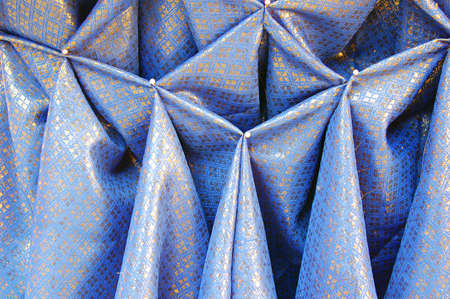 Blue and gold cloth with pinned pleatsの写真素材