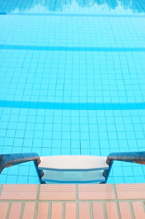 Clear blue empty swimming pool and ladderの写真素材