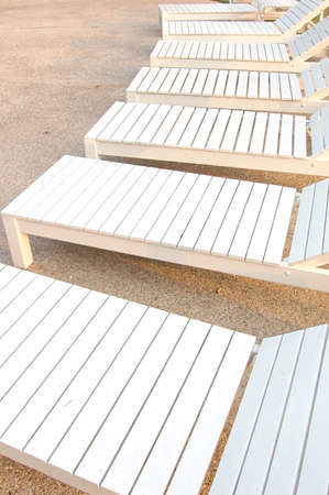 A line of wooden loungers near a hotel poolの写真素材