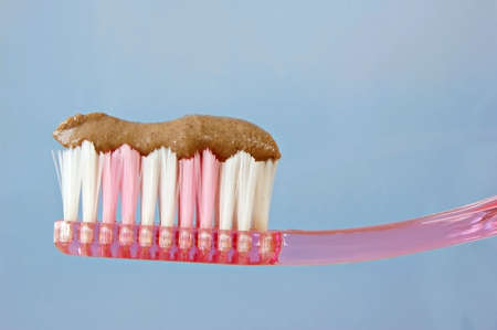 A toothbrush loaded with brown herbal toothpasteの写真素材