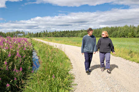 Couple walking along road in rural Finlandの写真素材