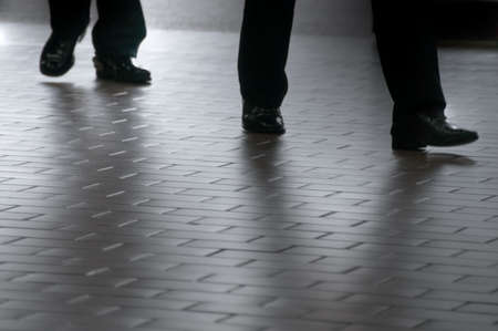 Two businessmen walking on a tiled floor