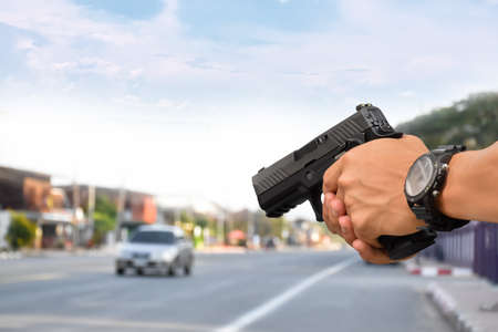 Automatic 9mm black pistol holding in hand, concept for robbery, security, safety, bodyguard,...