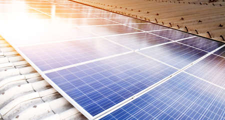 Photovoltaic panels installed on the toproof of the factory, sunlight cloudy and bluesky background....