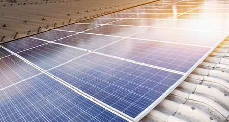 Photovoltaic panels installed on the toproof of the building, sunlight and cloudy bluesky...