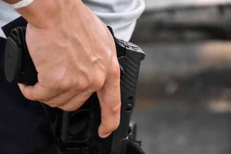 Automatic 9mm pistol holding in hand at the holster, it's ready to pull out and ready to shoot at...