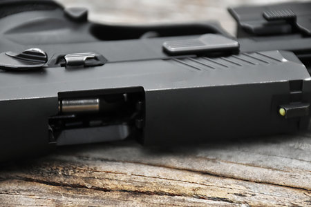 9mm automatic pistol holding in hand, copy space, soft and selective focus on pistol.
