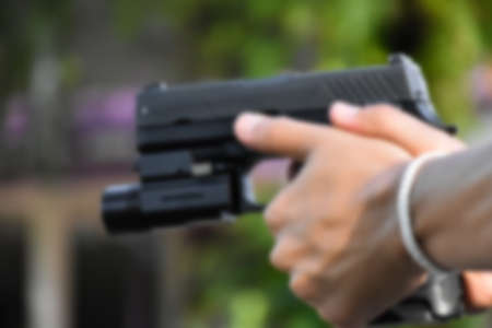 9mm automatic pistol holding in hand, copy space, soft and selective focus on pistol.の写真素材