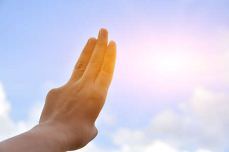 Hands of human in fist, three and two fingers show on cloudy and bluesky background. Soft and selective focus on fingers.の写真素材