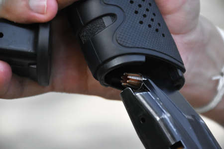 Gunman is changing empty bullet magazine with new full bulltet magazine into the pistol, Selective...