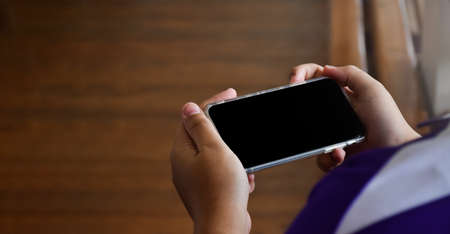 Blank touchscreen taplet holding in hands of female student, concept for using mobile phone to...