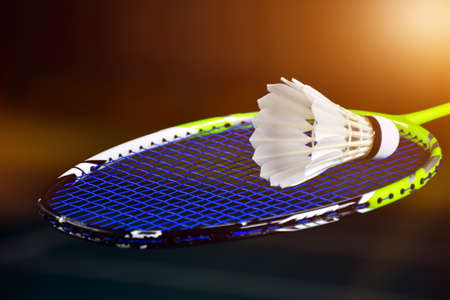 Closeup view of badminton racket and white badminton shuttlecock on badminton court. soft and selective focus on shuttlecock.の写真素材