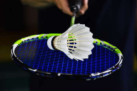 Closeup view of badminton racket and white badminton shuttlecock on badminton court. soft and selective focus on shuttlecock.の写真素材