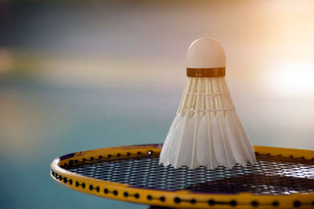 White badminton shuttlecock and racket on floor in badminton indoor court.の写真素材