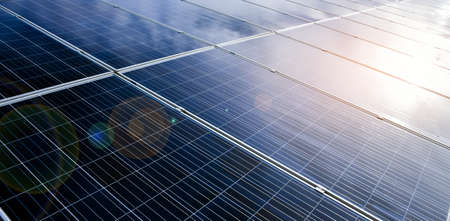 Photovoltaic panels with reflection of the Sunlight and clouds on the surface.の写真素材