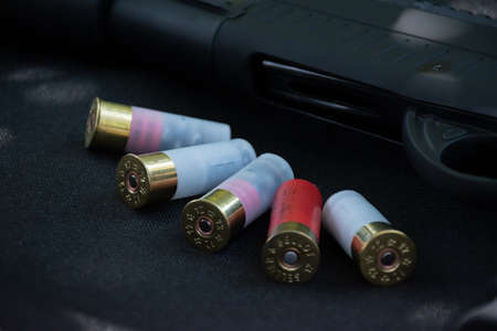 Shotgun, shotgun cartridges on a black leather background