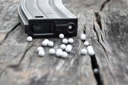 Closeup some parts of airsoft gun and bullets on a black leather background. Soft and selective...