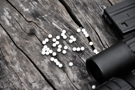 Closeup some parts of airsoft gun and bullets on a black leather background. Soft and selective...