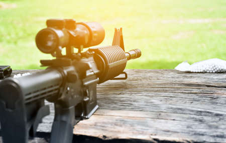 Closeup some parts of airsoft gun and bullets on a black leather background. Soft and selective...