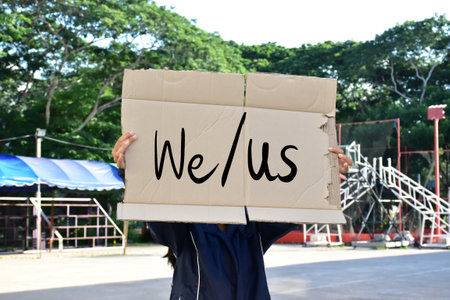 Subject and object pronouns 'We and us' on paper holding in hands of student. concept for English...
