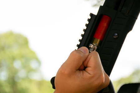 Shotgun shooter is changing and checking new shotgun cartridges with his shotgun, soft and selective...