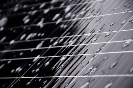 Closeup photovoltaic panel which had waterdrops and sponges on the surface, soft and selective focus, concept for using natural power in daily life around the world.の写真素材