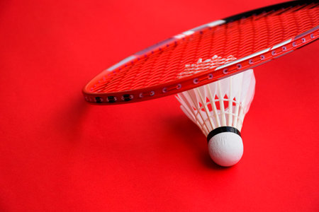 Cream white badminton shuttlecock and racket on floor in indoor badminton court, copy space, soft and selective focus on shuttlecocks.の写真素材