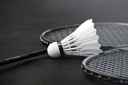 Cream white badminton shuttlecock and racket on red floor in indoor badminton court, copy space, soft and selective focus on shuttlecocks.の写真素材