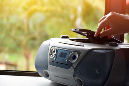 House owner is pressing the playing button on cassette player which is on the balcony near the glass...