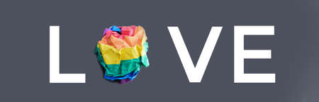 Paper balls made of wringled rainbow colored paper in "LOVE", concept for lgbtq+ communities celebrations in pride month around the world.の写真素材