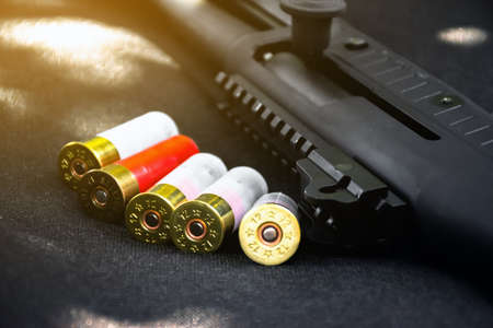 Shotgun and shotgun cartridges on a black leather background, soft and selective focus.の写真素材