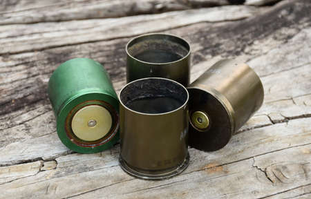 Old and used m203 bullet shells on wooden floor, soft and selective focus.