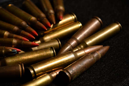 Pile M16 assault rifle cartridges on dark background.の写真素材